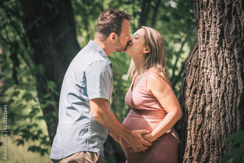 Family together in the summer park. Woman is pregnant Family together in the summer park. Woman is pregnant