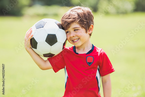 Young soccer player having fun on a field with ball