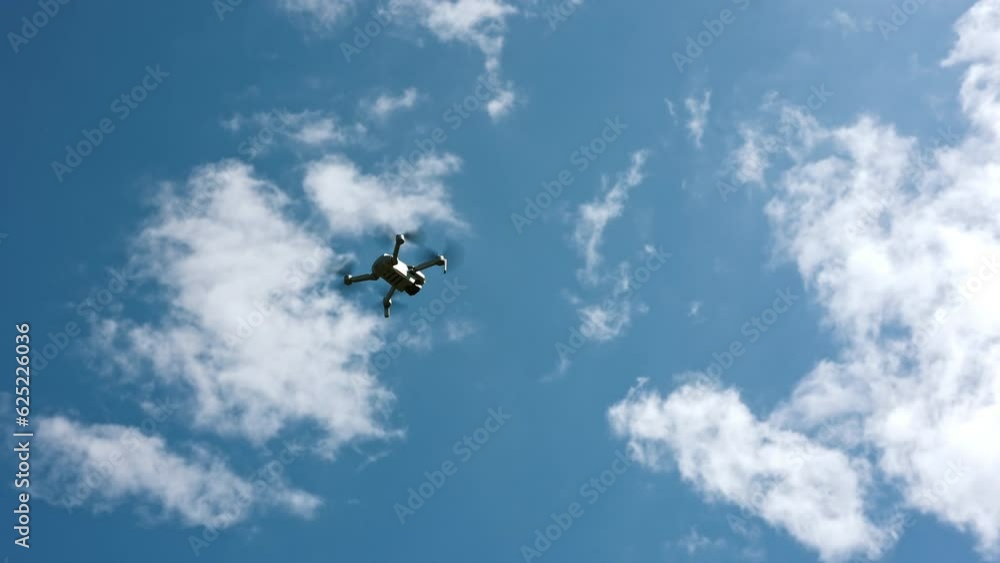 drone flying in silhouette against the blue sky, copter on a blurred background in the sunlight, slow motion drone flying in silhouette against the blue sky, copter on a blurred background in the sunlight, slow motion