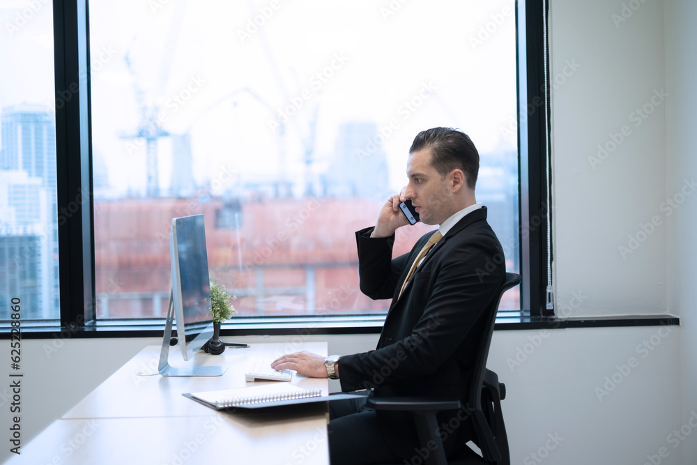 Business man using smartphone contact customer at desk on office in city with high building view, serious and intense emotion business onwer sitting beside glass window. Business man using smartphone contact customer at desk on office in city with high building view, serious and intense emotion business onwer sitting beside glass window.
