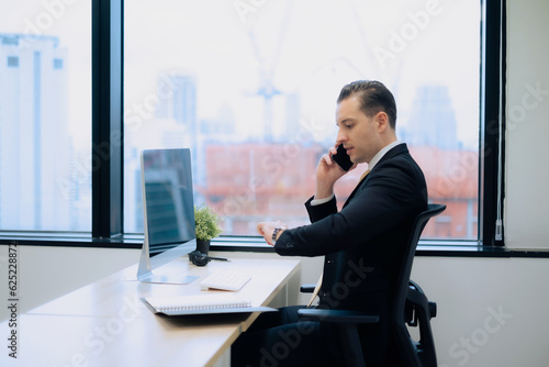 Business man using smartphone talking with customer while watching time to make appointment with intense and serious emotion.