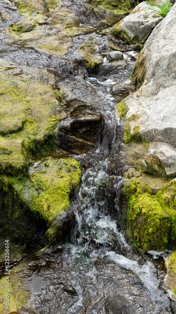 Water flow. Mountain stream of water. Water spring. Cascade waterfall. Waterfalls