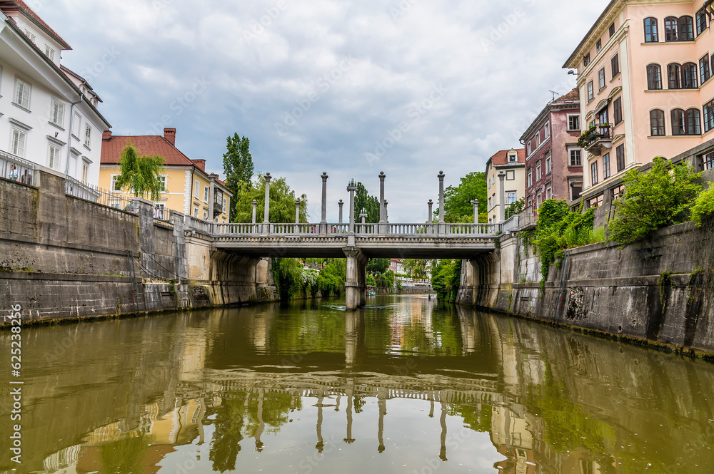 A view along the Ljubljanica River towards the Shoemakers Bridge in the center of Ljubljana, Slovenia in summertime