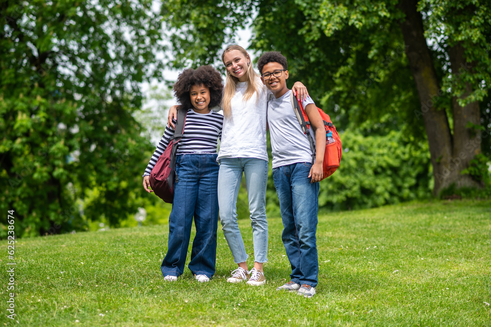Fototapeta premium Volunteer spending time with kids and all looking happy