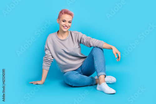 Full body portrait of stunning satisfied peaceful lady sit floor have good mood isolated on blue color background