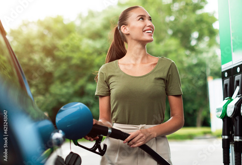 Canvas Print Lady Refilling Automobile With Fuel At Petrol Station Standing Outside