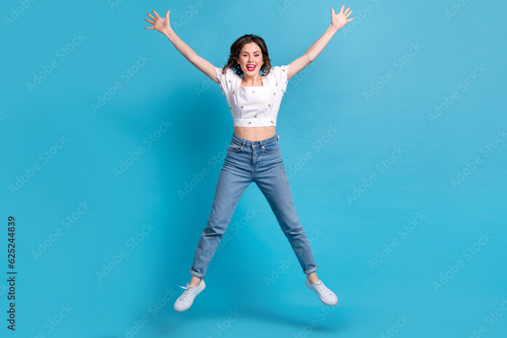 Full length photo of sweet excited girl dressed white top jumping high like star isolated blue color background