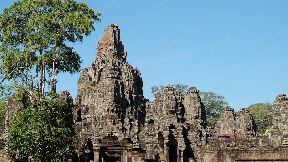 Photograph of the Bayon Temple in Cambodia, famed for its architecture, under the warm sun.