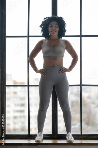 Sporty young woman in grey sportwear