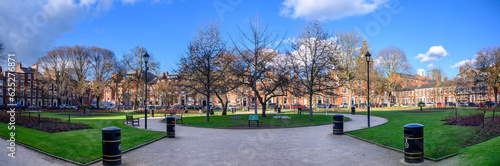 Bare winter trees and green garden in Park Square Leeds UK