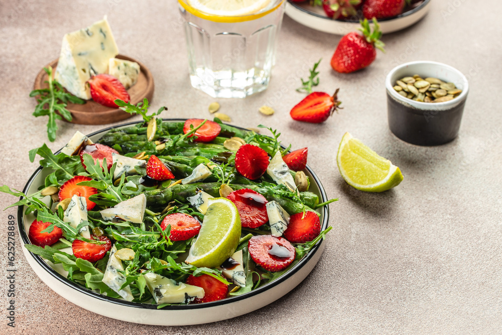 strawberry salad with asparagus, arugula, blue cheese and seeds. Delicious breakfast or snack, Clean eating, dieting, vegan food concept. top view strawberry salad with asparagus, arugula, blue cheese and seeds. Delicious breakfast or snack, Clean eating, dieting, vegan food concept. top view