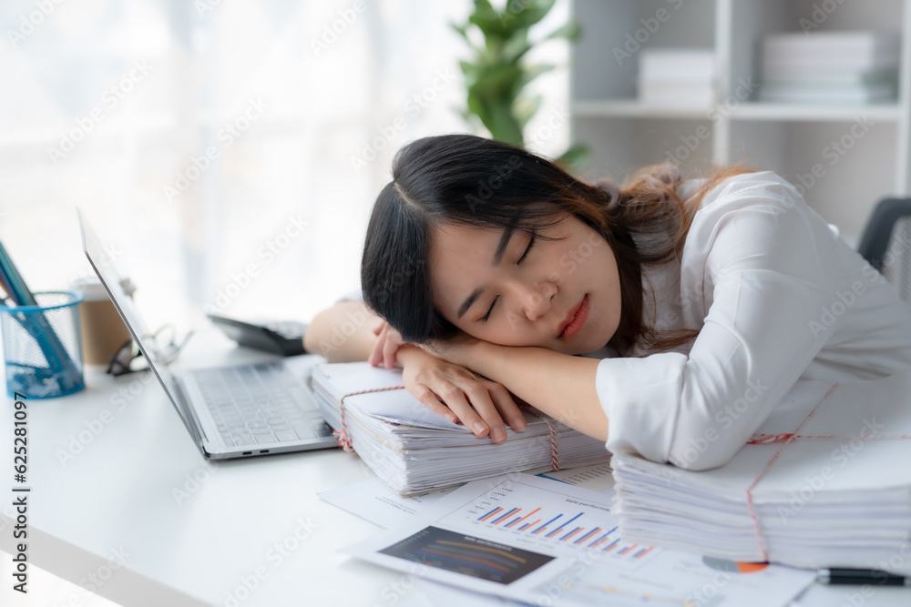 Asian businesswoman who is exhausted from work sleeping on the desk in the office. Asian businesswoman who is exhausted from work sleeping on the desk in the office.