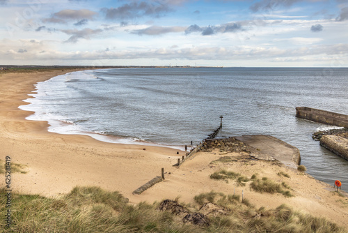 Looking north across Seaton Sluice beach towards Blyth, with the harbour mouth to the right, Northumberland.