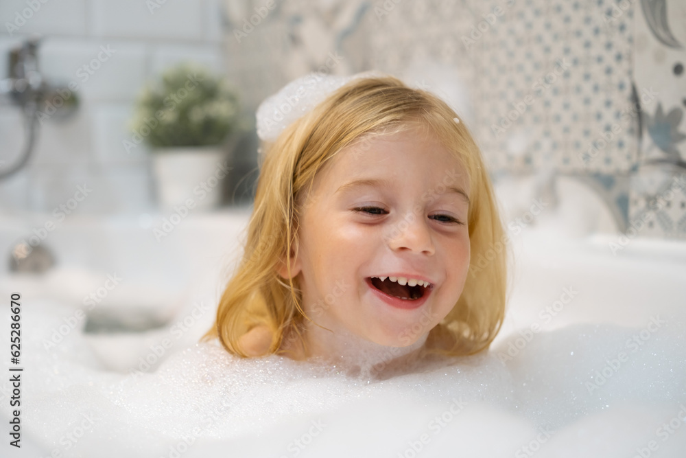 Adorable caucasian blonde two,three years old baby girl swimming in bath with soap foam bubbles, kid playing,smiling ,having fun.Carefree childhood, hygiene, healthcare and child body care concept. Adorable caucasian blonde two,three years old baby girl swimming in bath with soap foam bubbles, kid playing,smiling ,having fun.Carefree childhood, hygiene, healthcare and child body care concept.