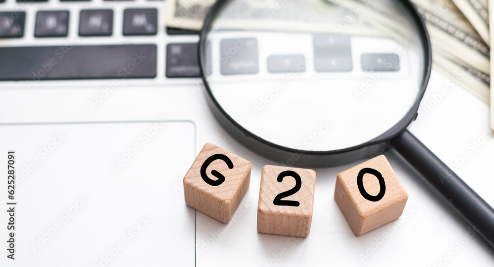 G20. Politics, economics and the concept of cooperation. Magnifying glass on a white background.