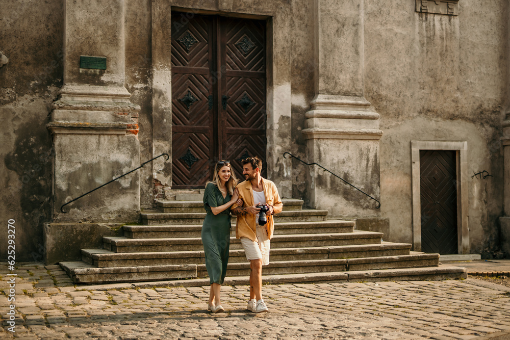 A loving couple strolls along a vibrant street, admiring the colorful buildings and street art. A loving couple strolls along a vibrant street, admiring the colorful buildings and street art.
