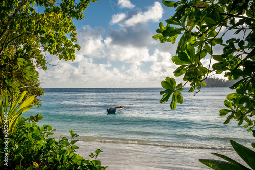 Summer landscape in the Seychelles. A beautiful bay with a boat surrounded by tropical defiles. Paradise tropical beach at sunset. Mae Island photo