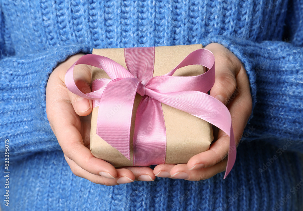 Woman holding gift box with pink bow, closeup Woman holding gift box with pink bow, closeup