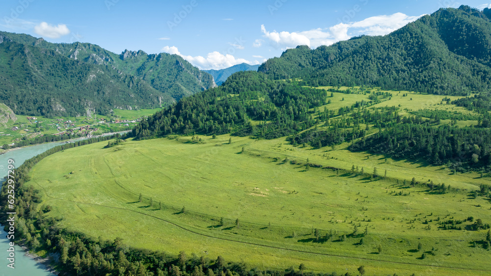 View of the Katun river in the Altai near Chemal. Mountain valley Che-Chkysh. Summer landscape. Turquoise river, mountains and green meadows