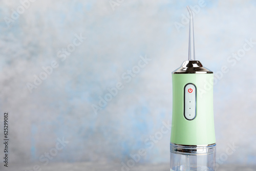 Electronic oral irrigator on textured marble background. Dental tool for oral hygiene. Electric Interdental Cleaner. Dental water shower. Oral care concept. Place for text. copy space. © Avocado_studio