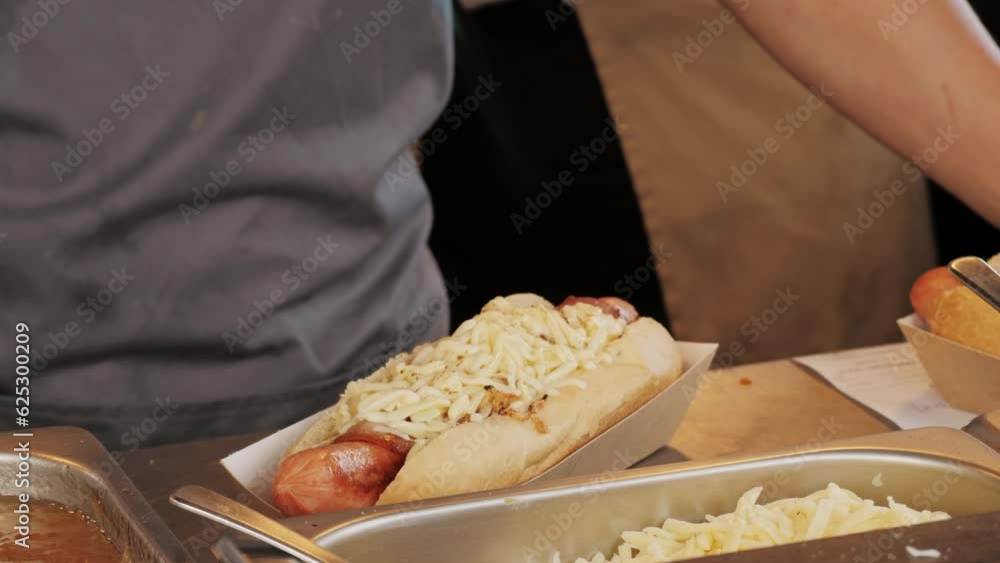 Cooking hot dogs in outdoor fast food restaurant, takeaway festival food truck. Sausages frankfurt and buns are fried and grill for delivery Cooking hot dogs in outdoor fast food restaurant, takeaway festival food truck. Sausages frankfurt and buns are fried and grill for delivery
