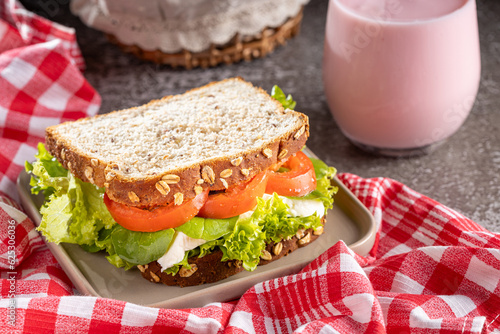 Delicious natural vegetable sandwich with white cheese and a glass of yogurt.