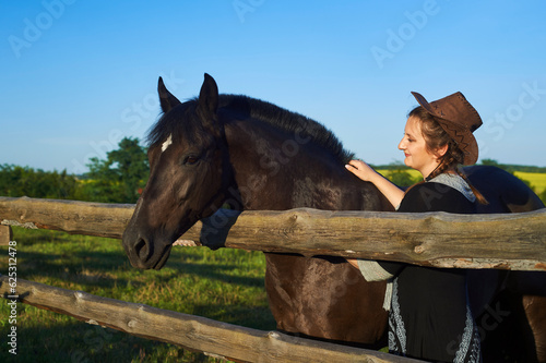 Beautiful girl with horse on the sunset