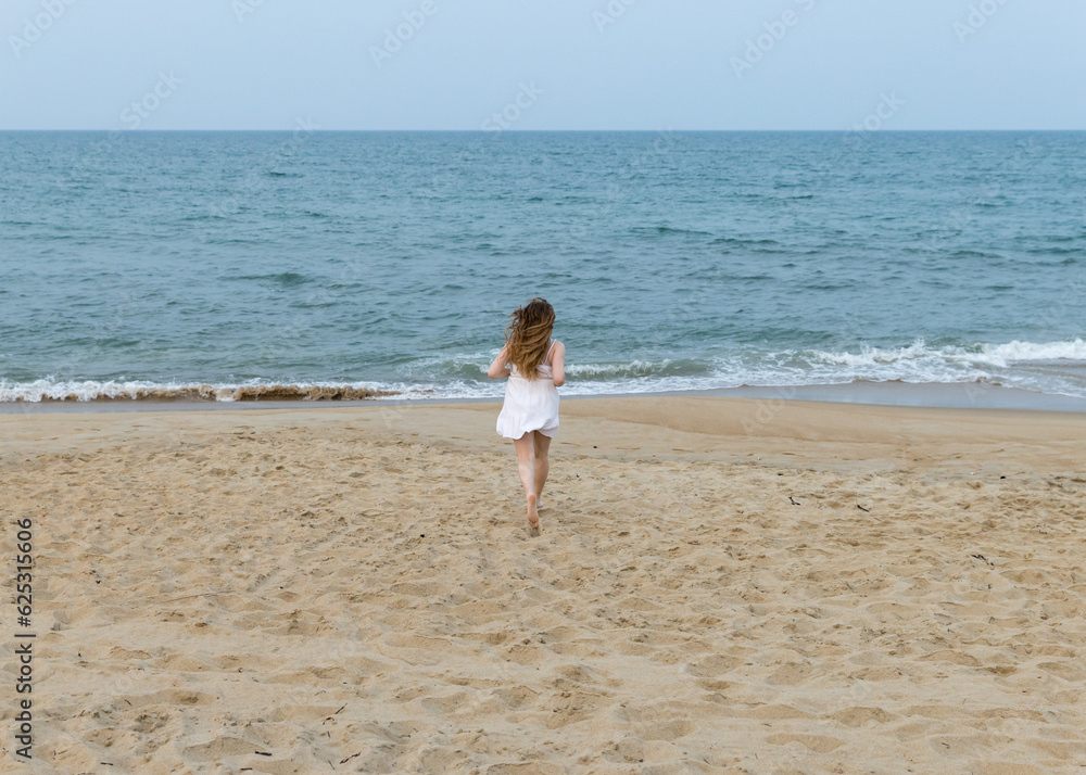 girl running towards ocean