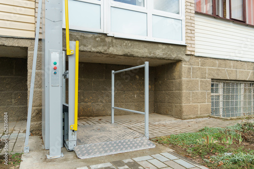 Outdoor elevator at the entrance of the house for people with disabilities. Modern electric elevator on the street for people traveling in a wheelchair. Taking care of the health of loved ones.