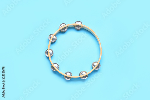 Stylish tambourine on color background, top view