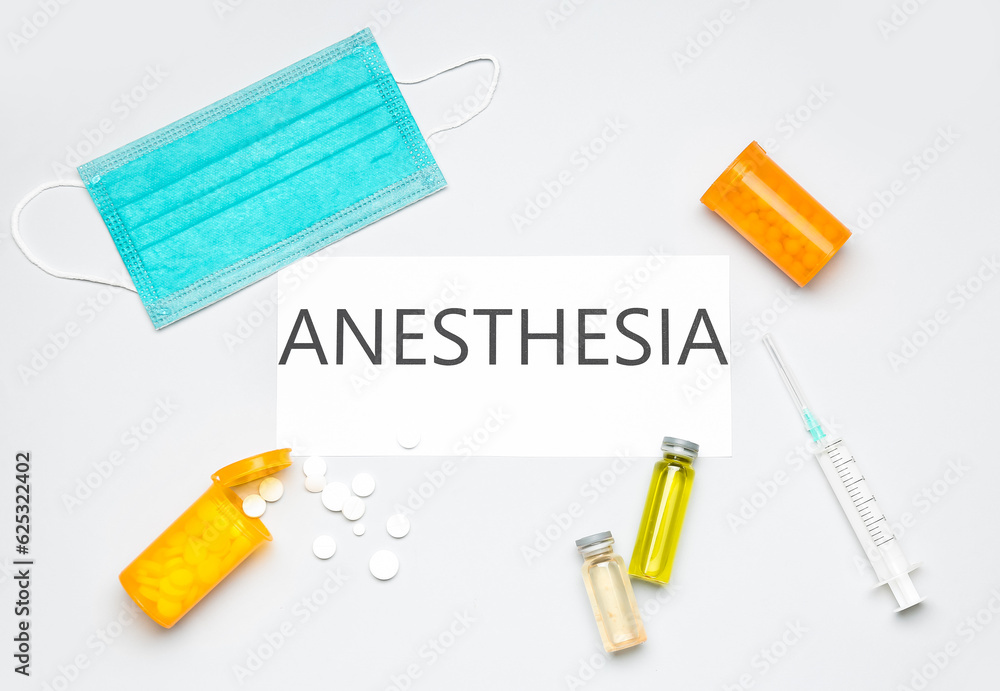 Paper with word ANESTHESIA, medical mask, pills and ampules on light background Paper with word ANESTHESIA, medical mask, pills and ampules on light background
