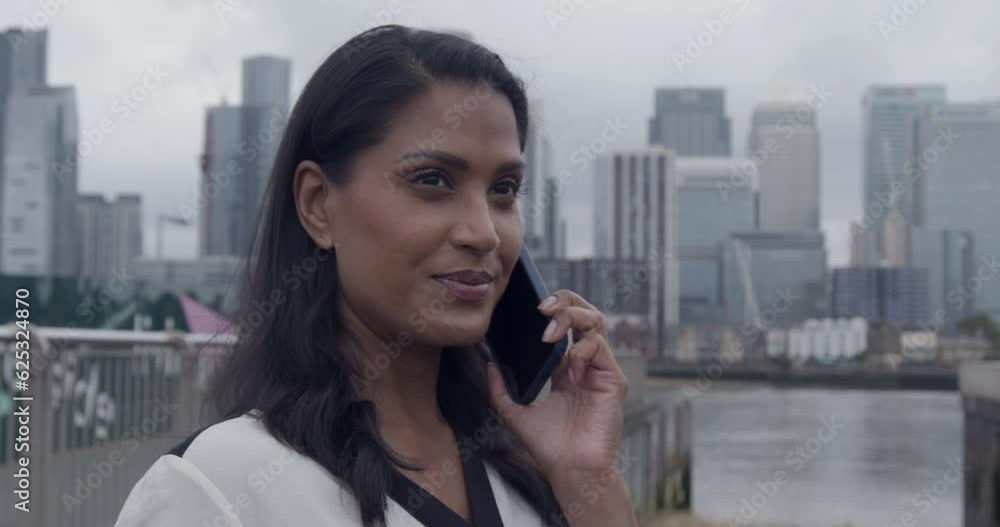Businesswoman holding Laptop and talking on Smart phone in City Businesswoman holding Laptop and talking on Smart phone in City