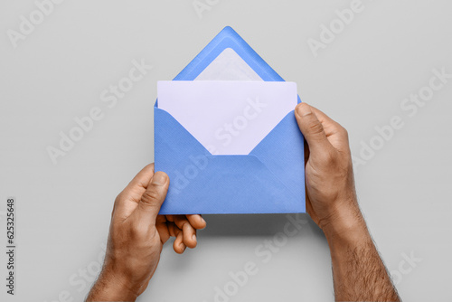 Hands holding open blue env...