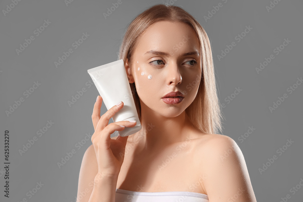 Sexy young woman with facial cream on grey background Sexy young woman with facial cream on grey background