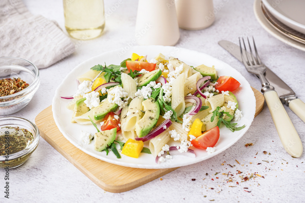 Plate of tasty pasta salad with tomatoes and avocado on white background Plate of tasty pasta salad with tomatoes and avocado on white background