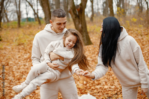 Young family standing in autumn forest and hugging © prostooleh