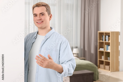 Happy man inviting to come in room