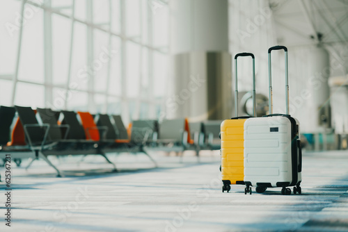 Two suitcases in an empty airport hall, traveler cases in the departure airport terminal waiting for the area, vacation concept, blank space for text message or design