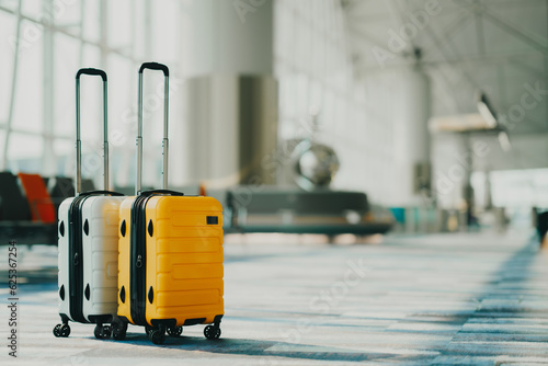 Two suitcases in an empty airport hall, traveler cases in the departure airport terminal waiting for the area, vacation concept, blank space for text message or design photo