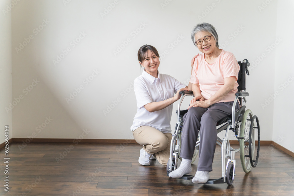 シニア・高齢者女性と話す介護士・看護師・理学療法士・ヘルパーのアジア人女性
