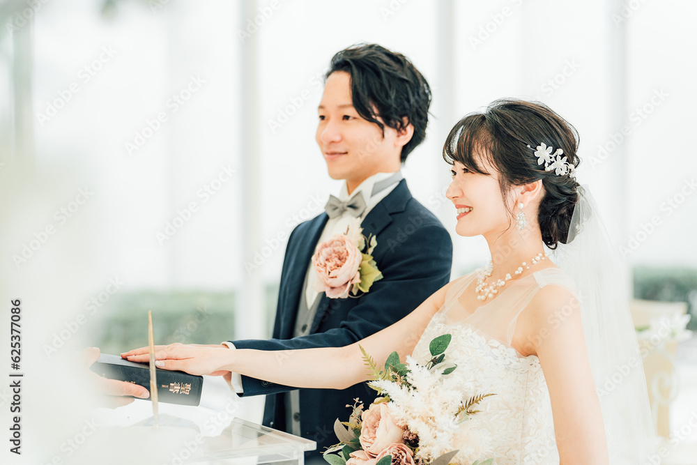 結婚式で聖書に手を重ねて宣誓・誓う新郎新婦 Stock Photo | Adobe Stock