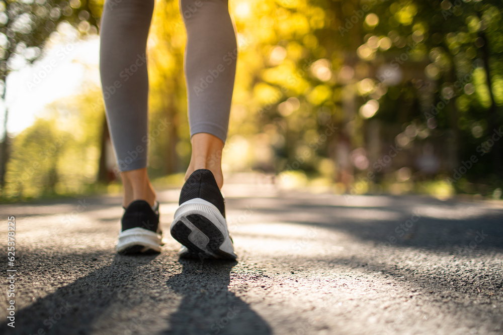 Active woman jogging walking outdoors in sunlight