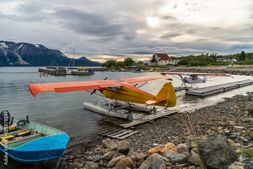 Valokuva Sea planes and boats tied to shore platforms and floats with a small marina and