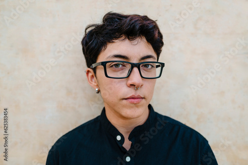 Close up view of a young transgender man looking at camera.