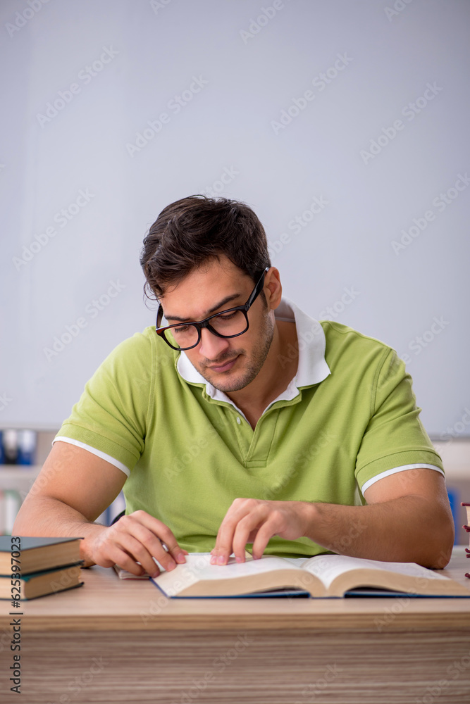 Young male student preparing for exams in the classroom Young male student preparing for exams in the classroom