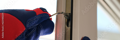Repairman in gloves installs and repairs windows and doors with his tools..