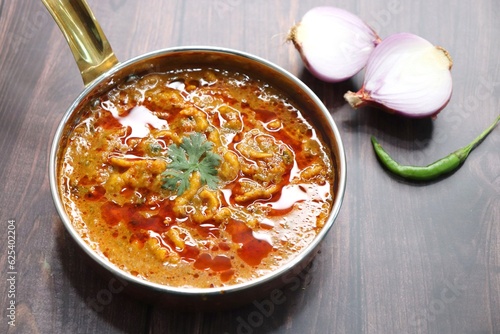 Traditional Sev bhaji or sev tamatar nu Shaak. its a sweet & spicy tomato curry topped with sev. Sev is a crisp fried gram flour vermicelli. Served with chopped onion and lemon. with Copy space. photo