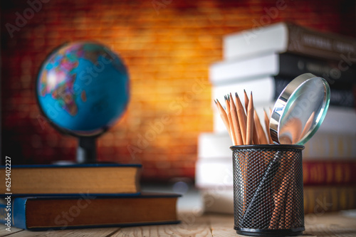 Textbooks,  globe and pencils on a wooden background. Educational background