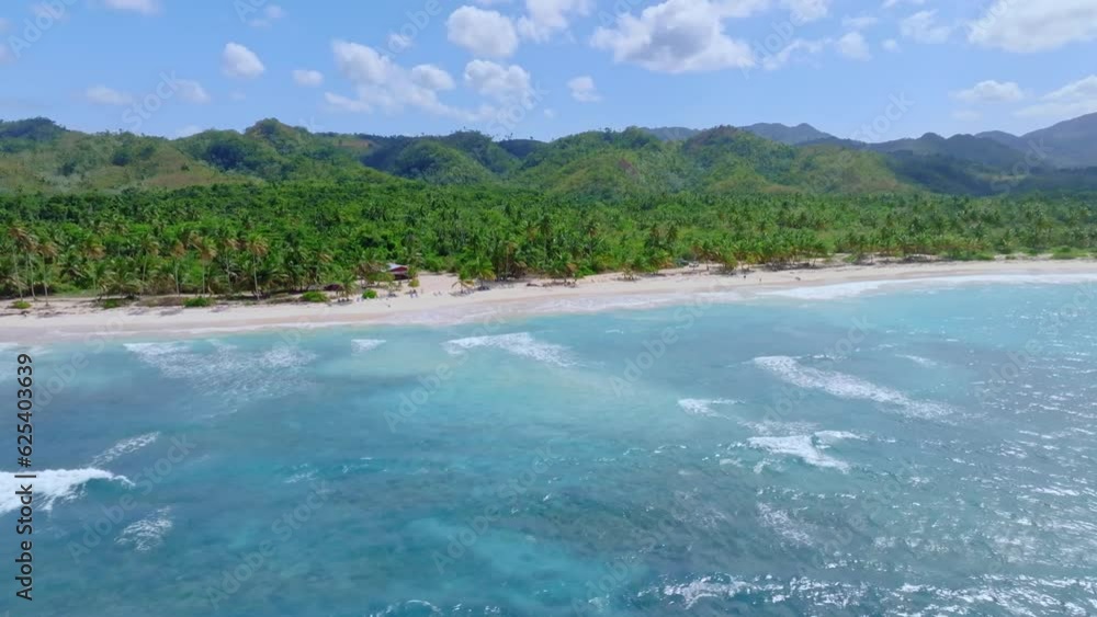 Aerial trucking shot showing beautiful Dominican Republic Island with green mountains , sandy beach and Blue Caribbean Sea in sunlight Aerial trucking shot showing beautiful Dominican Republic Island with green mountains , sandy beach and Blue Caribbean Sea in sunlight
