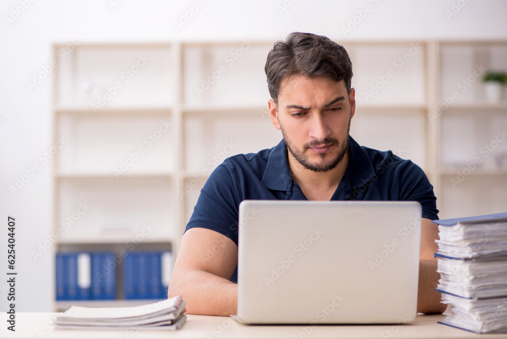 Young male employee sitting at workplace Young male employee sitting at workplace